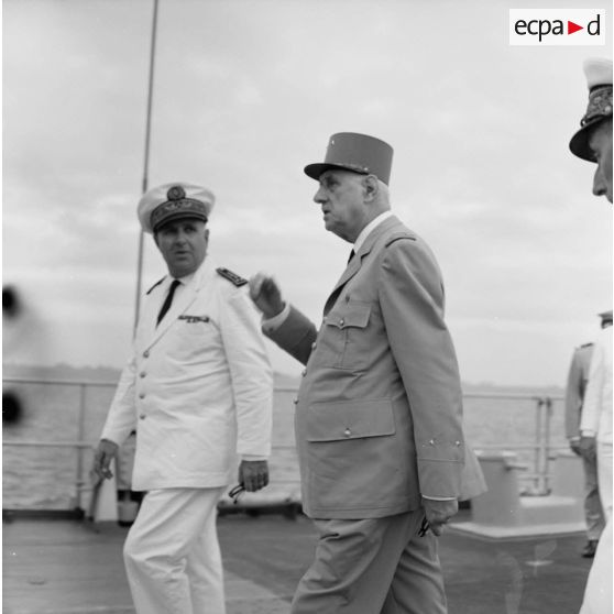 Le général Charles De Gaulle, président de la République, aux côtés du vice-amiral Jean Lorain, commandant du groupe opérationnel des expérimentations nucléaires (GOEN), à bord du croiseur De Grasse.