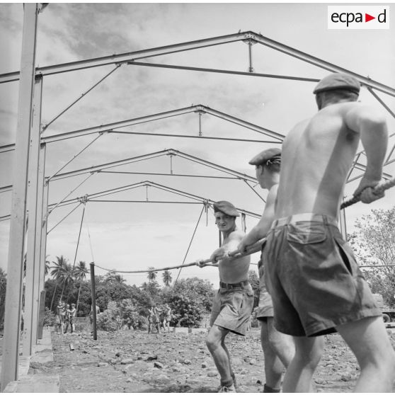 Montage de la structure métallique d'un hangar. Militaires du 5e régiment mixte du Pacifique (5e RMP). Peut-être la construction du camp d'Arue, vers 1963-1964.