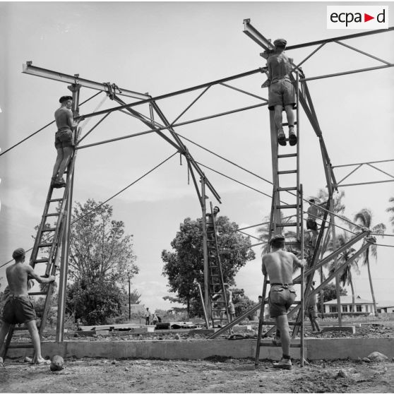 Montage de la structure métallique d'un hangar. Militaires du 5e régiment mixte du Pacifique (5e RMP). Peut-être la construction du camp d'Arue, vers 1963-1964.