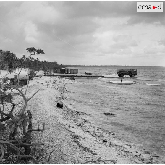 Camion-citerne et containers sur la jetée. Peut-être sur l'atoll d'Hao.