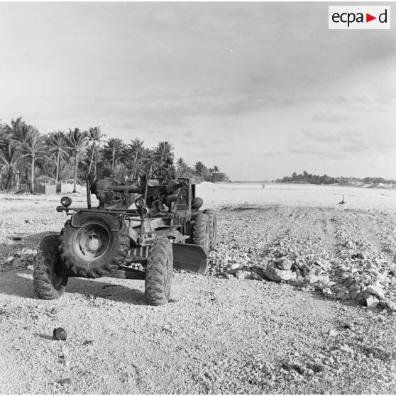 Construction de piste d'atterrissage. Engin du génie niveleuse Rhonelle. Peut-être sur l'atoll d'Hao.