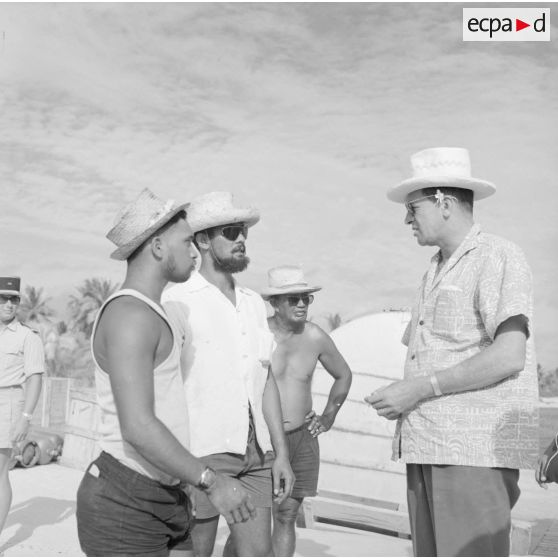 Jean Roy Bambridge, conseiller municipal de Papeete, apparenté UNR, avec des ouvriers polynésiens lors d'une visite à Moruroa sur le site du centre d'expérimentation du Pacifique (CEP) en construction, vers fin février-fin avril 1964.