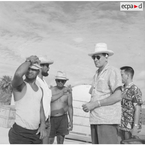 Jean Roy Bambridge, conseiller municipal de Papeete, apparenté UNR, avec des ouvriers polynésiens lors d'une visite à Moruroa sur le site du centre d'expérimentation du Pacifique (CEP) en construction, vers fin février-fin avril 1964.