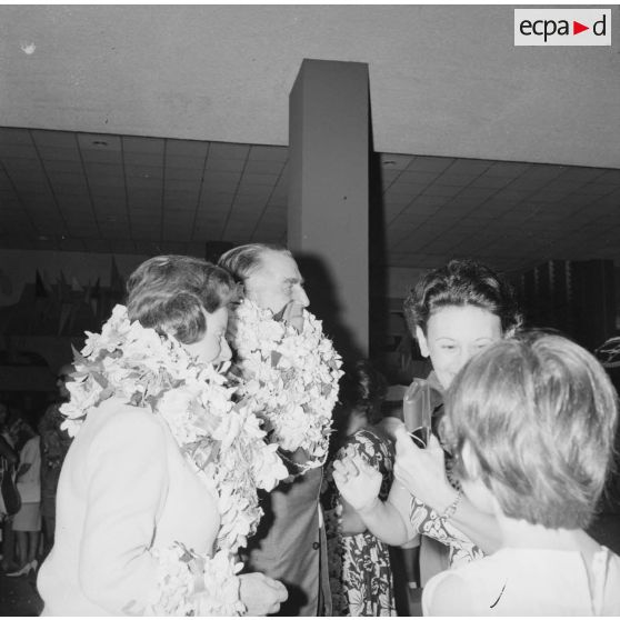 Arrivée du contre-amiral Jacques Thabaud, nouveau directeur du Centre d'expérimentations du Pacifique (CEP), et de son épouse, accueillis avec des colliers de fleurs à l'aéroport de Faa'a, 1964.