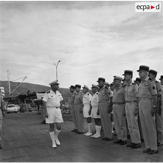 Revue des troupes par le capitaine de vaisseau Jean Pétesch, lors de la fin de son commandement du Centre d'expérimentations du Pacifique (CEP), port militaire de Fare ute à Papeete, mars 1964. En arrière-plan, le pétrolier tanker M.E. Lombardi.