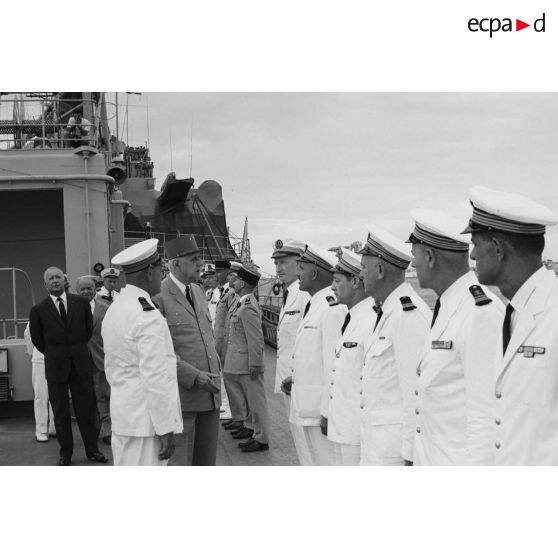 Le général Charles De Gaulle, président de la République, salue des officiers supérieurs de marine aux côtés du capitaine de vaisseau Michel Teisserenc, commandant du croiseur De Grasse