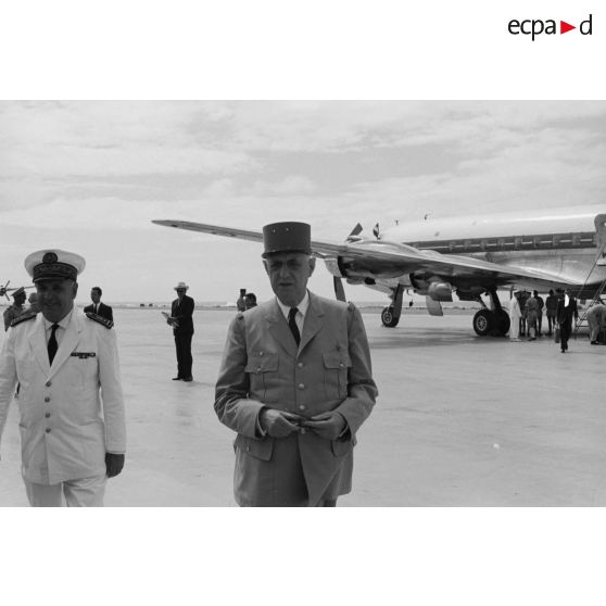 Le général Charles De Gaulle, président de la République, et le vice-amiral Jean Lorain, commandement du groupe opérationnel des expérimentations nucléaires (GOEN), au pied de l'avion à l'aéroport de Moruroa.