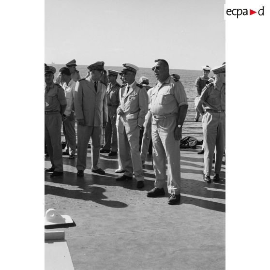 Le vice-amiral Jean Lorain, commandant du groupe opérationnel des expérimentations nucléaires (GOEN) et le général de corps aérien Jean Thiry, directeur des centres d'expérimentations nucléaires (DIRCEN), et le général de brigade Maurice André, chef du service mixte de sécurité radiologique (SMSR), à bord du croiseur De Grasse après le déclenchement de l'essai nucléaire Bételgeuse sur l'atoll de Moruroa.