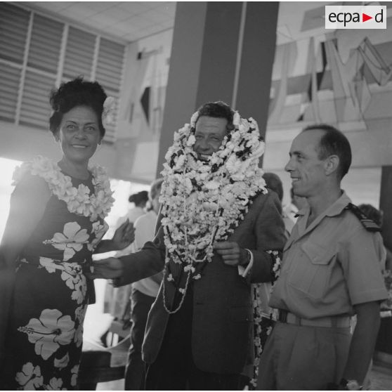 Départ à l'aéroport de Camussot (?), commandant l'aviso-escorteur Francis Garnier (F730), des colliers de fleurs autour du cou, salué par un commandant.