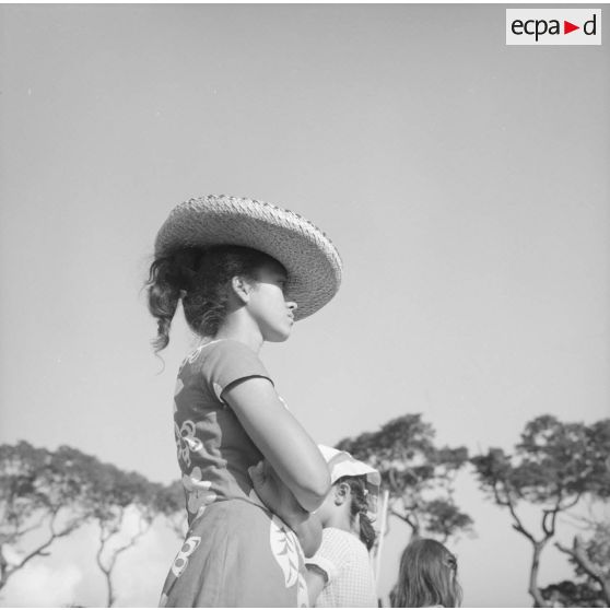 Fêtes du Juillet ou fête du Tiurai à Papeete en 1964. Portrait d'une jeune femme polynésienne avec un chapeau.