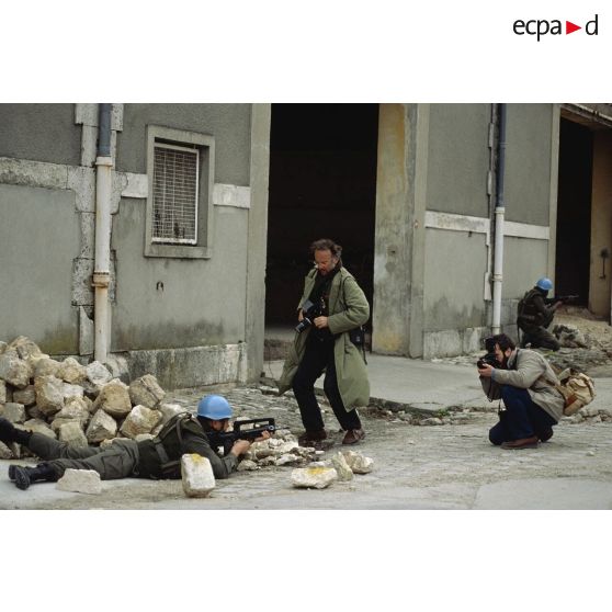 Deux photographes font des clichés d'un casque bleu du 1er régiment d'infanterie de marine (1er RIMa) lors d'un exercice de combat urbain dans la cour de la caserne d'Angoulême.