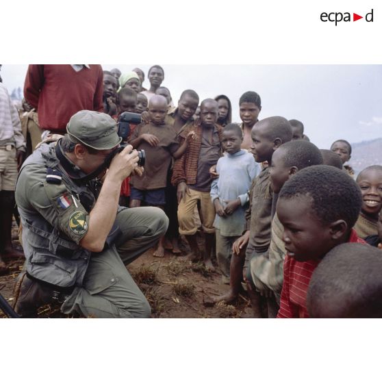 Opérateur de prises de vue de l'Etablissement cinématographique et photographique des armées photographiant un groupe d'enfants rwandais dans le camp de Nyacyonga.