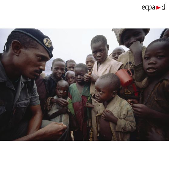 Camp de réfugiés de Nyacyonga sur la route de Byumba à 10 km de Kigali. Militaire français parmi les réfugiés et tentant de sympathiser avec les enfants.