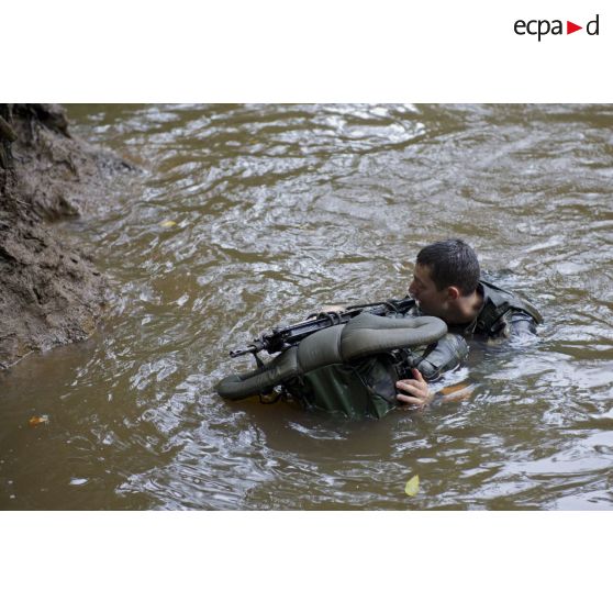 Un stagiaire apprend à traverser une crique avec sac et armement sur la zone d'instruction de Tuff, en Guyane française.