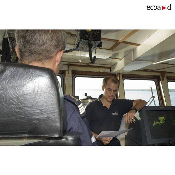 Une enseigne de vaisseau participe à un briefing aux côtés du capitaine de corvette Egide Brunet en passerelle de La Gracieuse, en Guyane française.