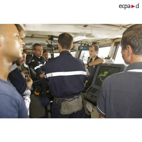 Une enseigne de vaisseau participe à un briefing aux côtés du capitaine de corvette Egide Brunet en passerelle de La Gracieuse, en Guyane française.