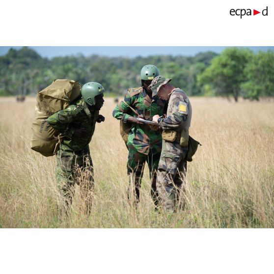 Le chef de l'équipe marquage du 2e régiment étranger de parachutistes (REP) se coordonne avec deux soldats ivoiriens du 1er bataillon de commandos et de parachutistes (BCP) sur la zone de saut d'Assinie, en Côte d'Ivoire.