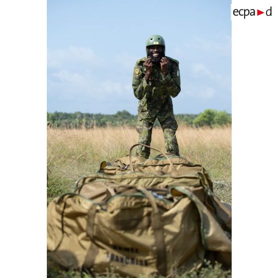 Un soldat ivoirien du 1er bataillon de commandos et de parachutistes (BCP) rassemble les parachutes à son arrivée sur la zone de saut d'Assinie, en Côte d'Ivoire.