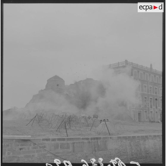 Sur le tournage du film Le jour le plus long en Normandie. Les figurants se déploient lors d'une scène de combat sur le port en centre-ville. En arrière-plan, la tour Vauban.