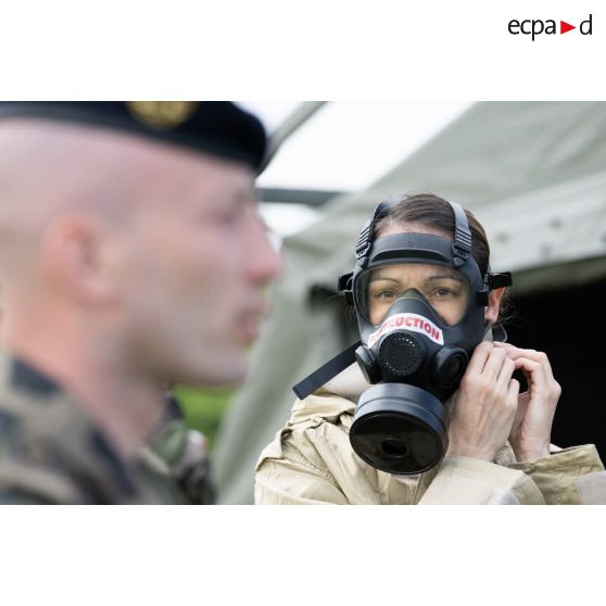 Une élève-praticienne enfile un masque de protection pour un exercice de défense nucléaire, radiologique, bactériologique et chimique (NRBC) à la Valbonne.