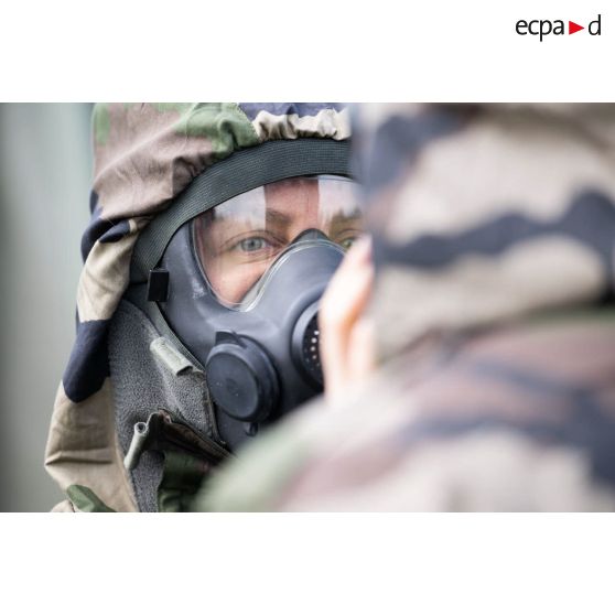 Un élève-praticien enfile un masque de protection pour un exercice de défense nucléaire, radiologique, bactériologique et chimique (NRBC) à la Valbonne.