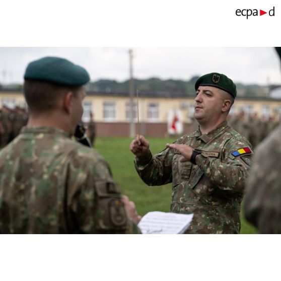 Un chef d'orchestre dirige la musique militaire roumaine pour la sonnerie des hymnes nationaux lors d'une cérémonie à Cincu, en Roumanie.