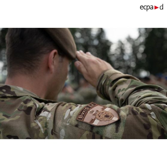 Un soldat belge salut lors de la sonnerie des hymnes nationaux pour une cérémonie à Cincu, en Roumanie.