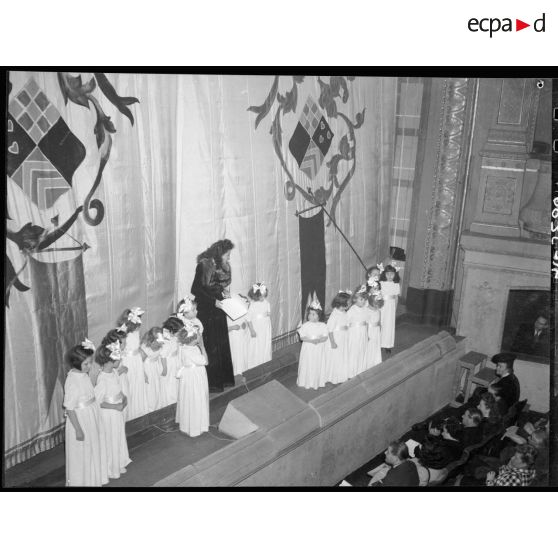 Au théâtre Antoine, à Paris, à l'occasion d'un gala de bienfaisance, une femme se tient debout sur la scène.