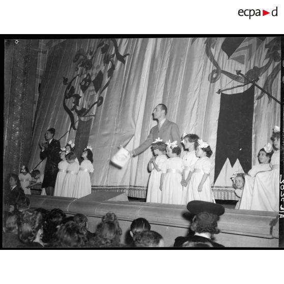 Adjudication du "parachutiste en or" par Joséphine Baker et Jean Tranchant à une personne du public du gala de bienfaisance au théâtre Antoine, à Paris.