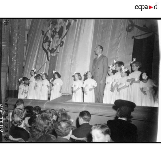 Jean Tranchant se tient sur les planches du théâtre Antoine, à Paris, à l'occasion d'un gala de bienfaisance. On aperçoit le public.