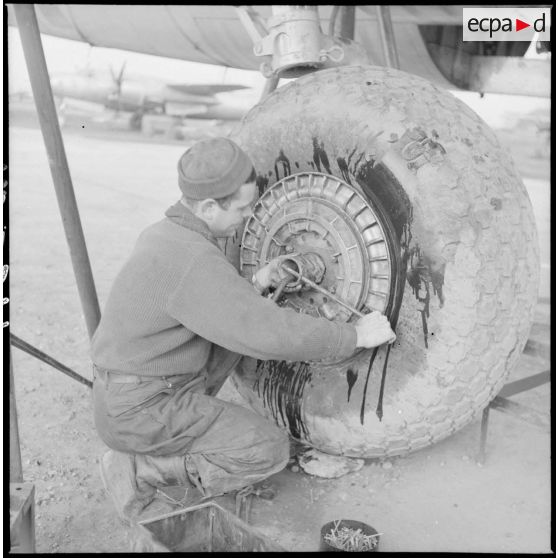 Avant la mission, un mécanicien s'affaire autour d'une roue d'avion Marauder.