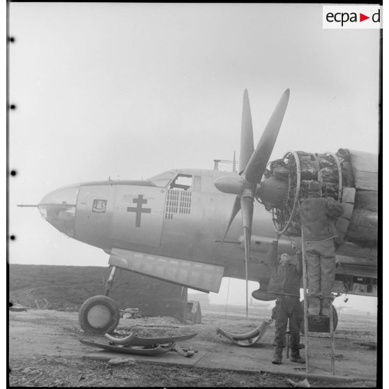 Deux mécaniciens réparent le moteur d'un avion Marauder.