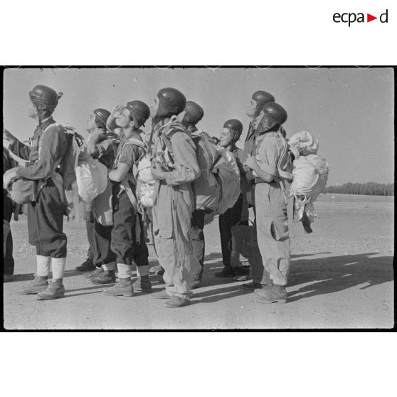 Des élèves parachutistes regardent leurs camarades descendre en parachute sur la base aérienne de Casbah Tadla.