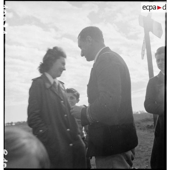 Un capitaine de corvette discute avec une femme.