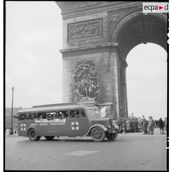 Arrivée à l'Arc de Triomphe, à bord d'un bus de la Croix-Rouge, de prisonniers de guerre français libérés de camps en Allemagne.