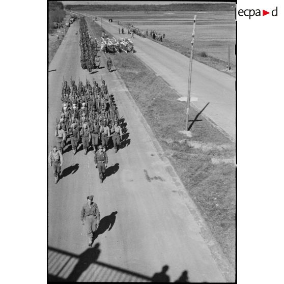 Vue en plongée sur le défilé des troupes à pied de la 2e division d'infanterie marocaine (2e DIM) au cours d'une prise d'armes sur une autoroute près de Karlsruhe.