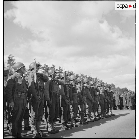 Les troupes de la 2e division d'infanterie marocaine (2e DIM) présentent les armes.au cours de la cérémonie présidée par le général de Gaulle sur une autoroute près de Karlsruhe.