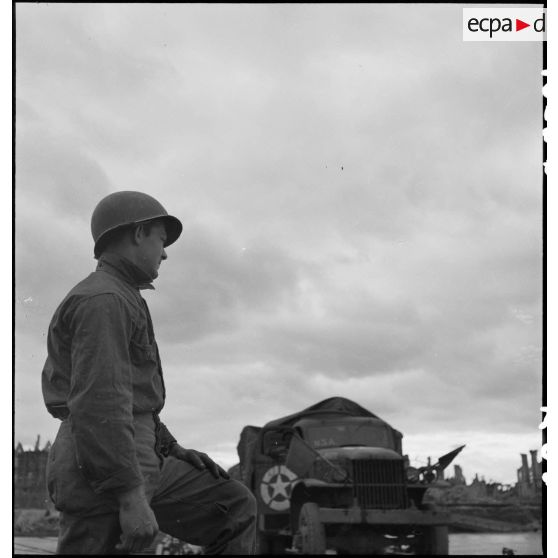 Un soldat américain regarde passer un GMC sur le pont flottant monté par le génie américain entre Mannheim et Ludwigshafen.