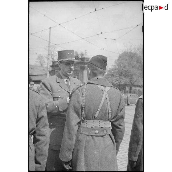 Lors d'une prise d'armes à Karlsruhe, le général de Gaulle décore un capitaine d'une unité de la 9e division d'infanterie coloniale (9e DIC).