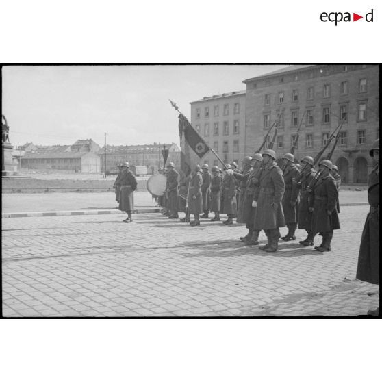 Le drapeau du 21e régiment d'infanterie coloniale (21e RIC) et une musique de la 9e division d'infanterie coloniale (9e DIC) sont sur les rangs lors de la prise d'armes présidée par le général de Gaulle.