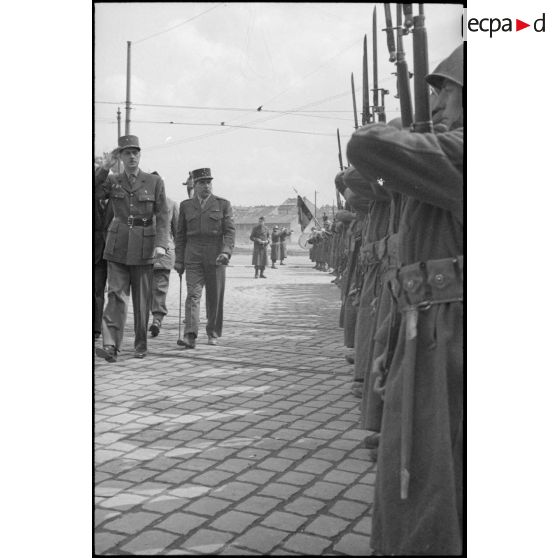 Au cours de la prise d'armes à Karlsruhe, le général de Gaulle, suivi du général de Lattre de Tassigny, passe les troupes en revue.