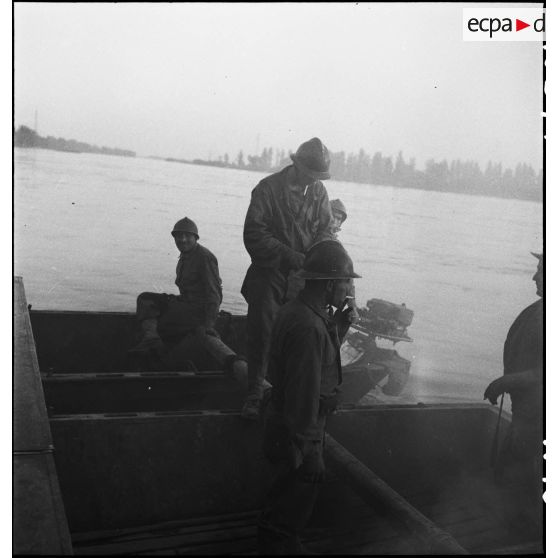 Des propulsistes du génie manoeuvrent des bateaux d'assaut M2 assemblés pour former une portière et transporter des véhicules sur le Rhin.