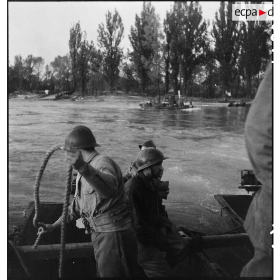 Des véhicules franchissent le Rhin sur des bateaux d'assaut M2 assemblés pour former une portière de transport et manoeuvrés par des équipages du génie.