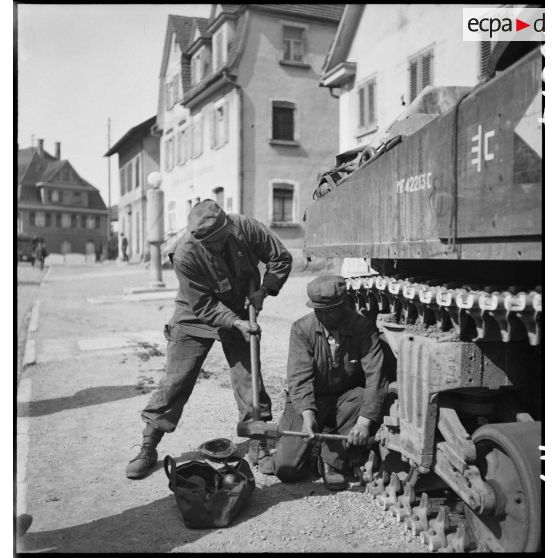 Intervention sur les galets d'une chenille d'un char Sherman M4 par des soldats du 11e GERD (11e groupe d'escadrons de réparation divisonnaire).