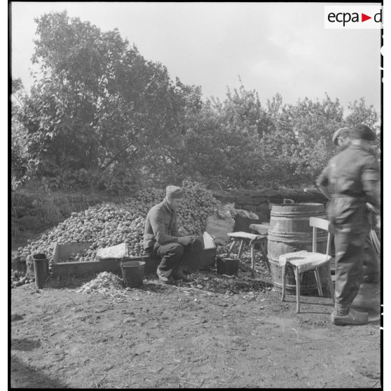 Corvée d'épluchage de pommes de terre dans un camp de prisonniers allemands capturés lors des combats pour la libération de la poche de Lorient et de la capitulation de la garnison allemande.