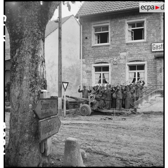 Groupe de prisonniers de guerre allemands rassemblés bras en l'air dans une commune à proximité de Fützen (secteur Singen - Blumberg - Waldshut).