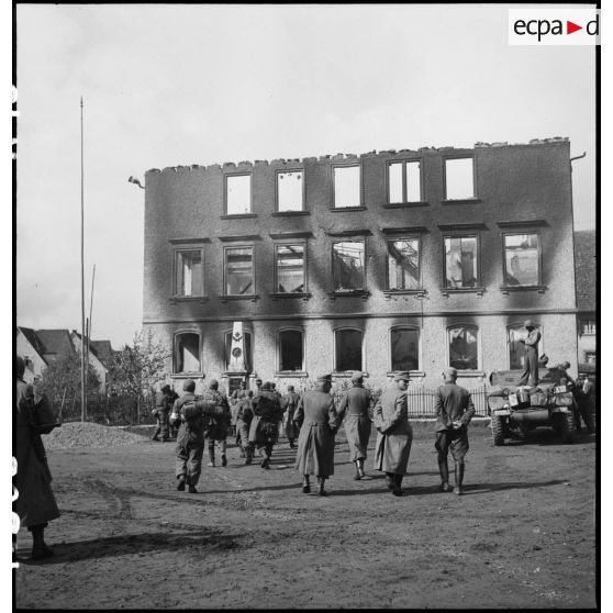 Rassemblement de prisonniers de guerre allemands à l'hôtel de ville de Fützen en ruine.