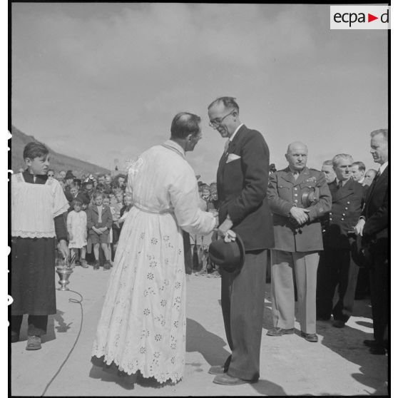 Le prêtre salue les autorités à l'issue de la messe dite lors de la cérémonie de commémoration du débarquement du 6 juin 1944 sur Omaha Beach.