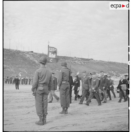 Les autorités saluent le fanion d'une compagnie d'une unité américaine du génie lors de la cérémonie de commémoration du débarquement du 6 juin 1944 sur Omaha Beach.