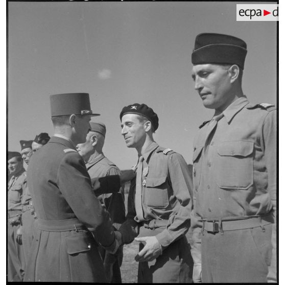 Lors de la cérémonie d'adieu à la 2e division blindée (2e DB), le général de corps d'armée Leclerc remet la croix de chevalier de la Légion d'honneur au capitaine André Janney du 501e régiment de chasseurs de chars (501e RCC).